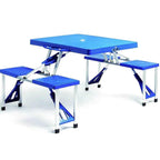 Table de camping pliante avec chaises intégrées dépliée sur une aire de pique-nique