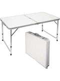 Table de jardin pliante valise de 120 cm dépliée sur une pelouse